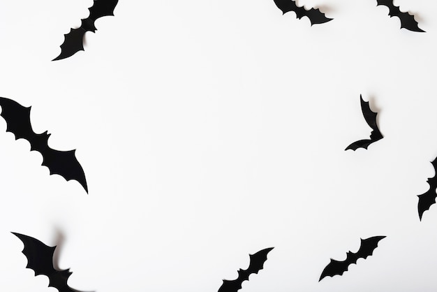 Murciélagos de papel colgando de la pared blanca