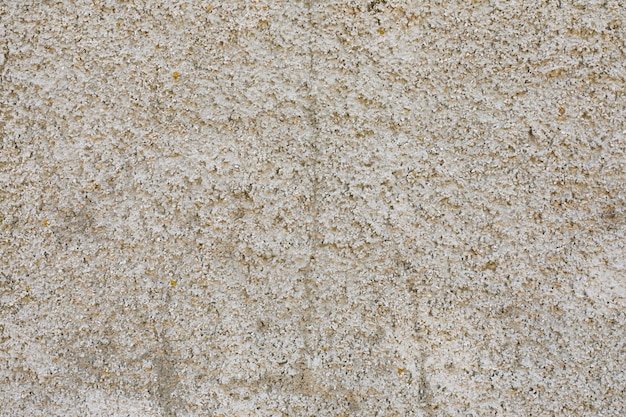 Muro de hormigón con superficie rugosa y grietas.
