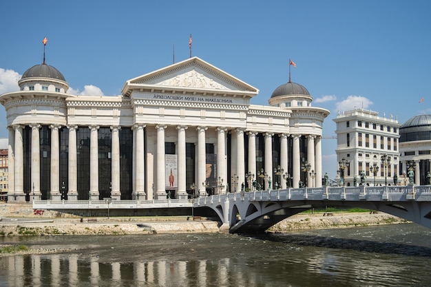 Museo arqueológico de macedonia rodeado por un río con un puente en el norte de macedonia