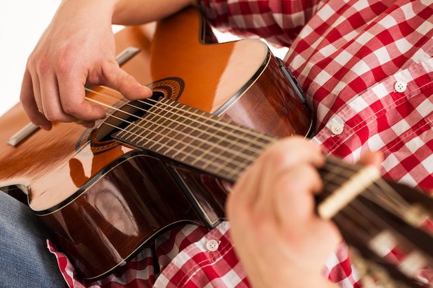 Música, primer plano. Músico sosteniendo una guitarra de madera