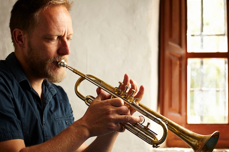 Foto gratuito músico concentrado tocando su instrumento