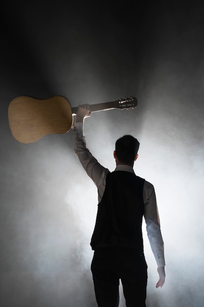 Foto gratuita músico en el escenario con su guitarra clásica