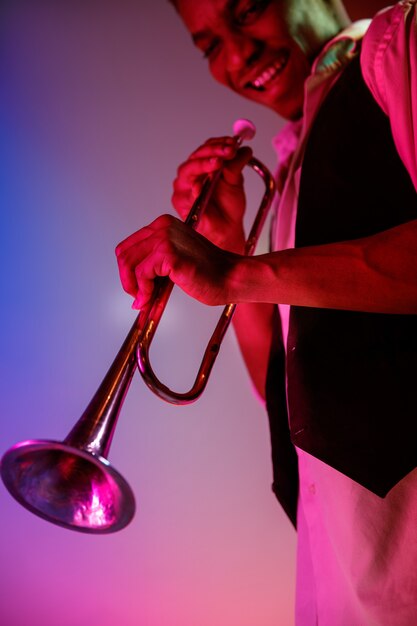 Músico de jazz afroamericano tocando la trompeta.