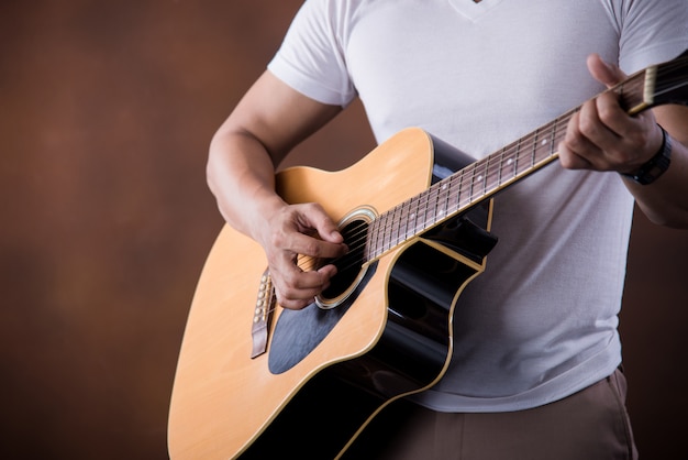 Músico joven asiático con guitarra acústica