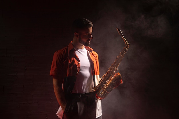 Músico masculino en el centro de atención con saxofón