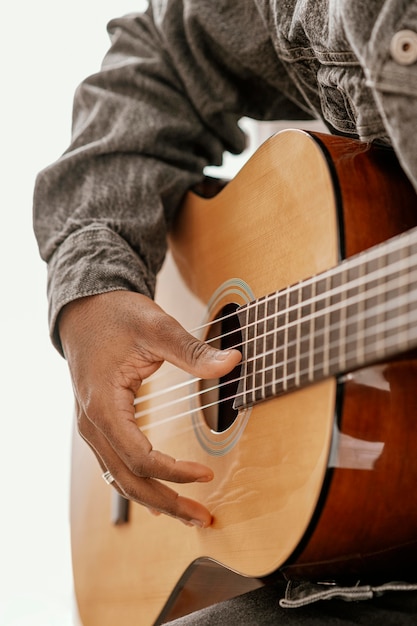 Músico masculino tocando la guitarra en casa