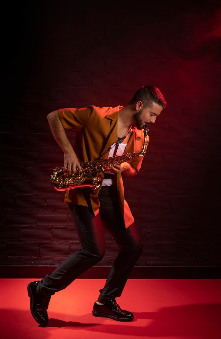 Foto gratuito músico masculino tocando el saxofón en la niebla con espacio de copia