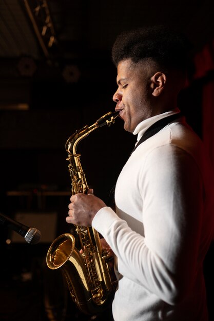 Músico de tiro medio tocando el saxofón.