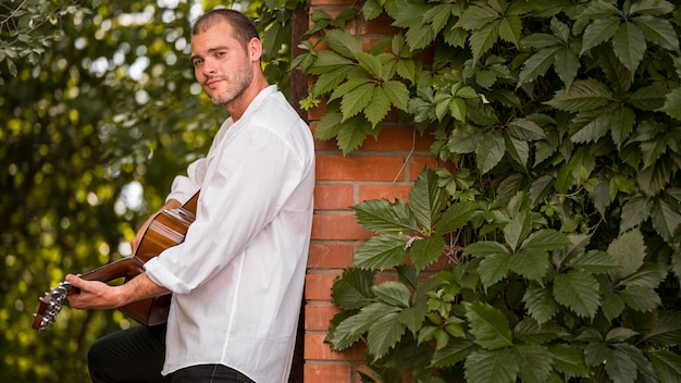 Foto gratuita músico tocando la guitarra acústica al aire libre