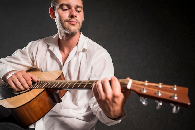 Foto gratuita músico tocando la guitarra acústica