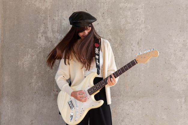 Músico tocando la guitarra de tiro medio