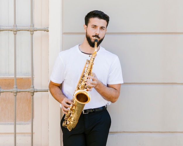 Músico tocando el saxofón y mirando a cámara