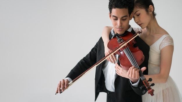Músico tocando el violín con bailarina y copia espacio