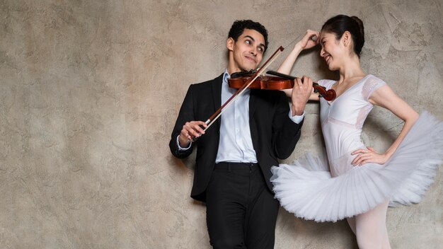 Foto gratuita músico tocando violín y bailarina escuchando