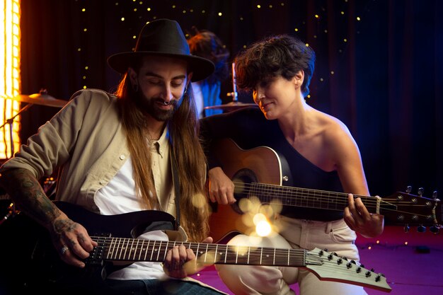 Músicos de tiro medio tocando las guitarras