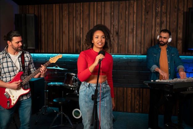 Foto gratuita músicos de tiro medio trabajando en estudio.