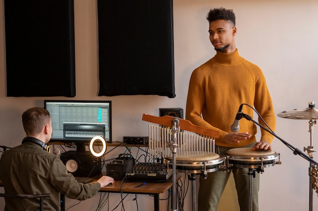 Músicos de tiro medio trabajando en estudio.