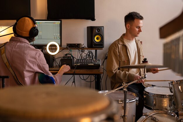 Músicos de tiro medio trabajando en estudio.