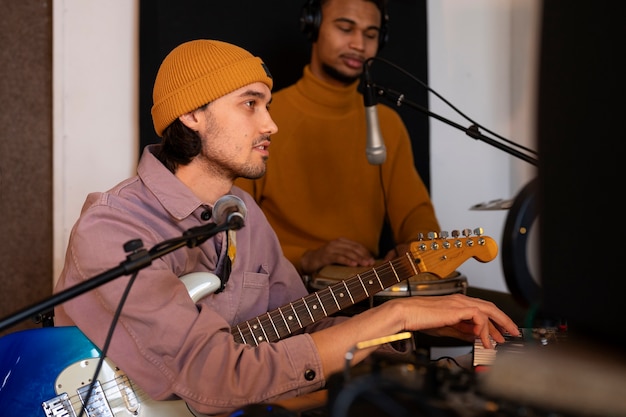 Músicos de tiro medio trabajando en estudio.