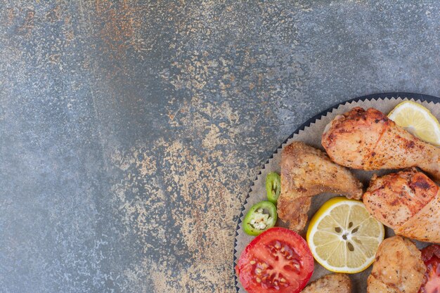 Muslos y alas de pollo asado a bordo con verduras. Foto de alta calidad