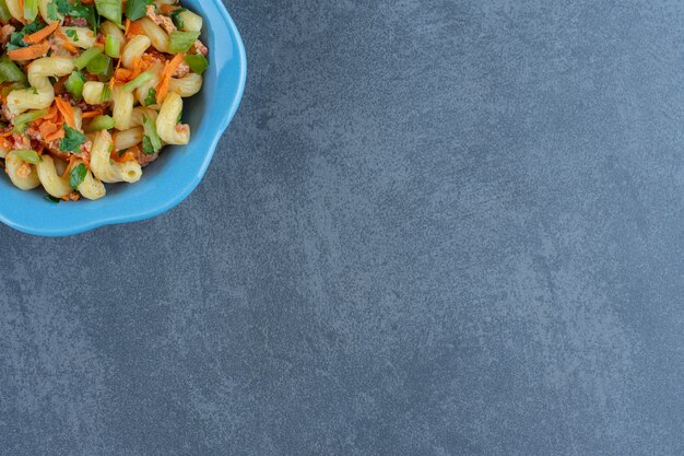 Muslos de pollo asado y pasta sobre pieza de madera.