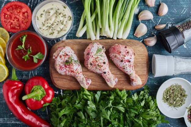 Muslos de pollo crudo en un plato de madera.