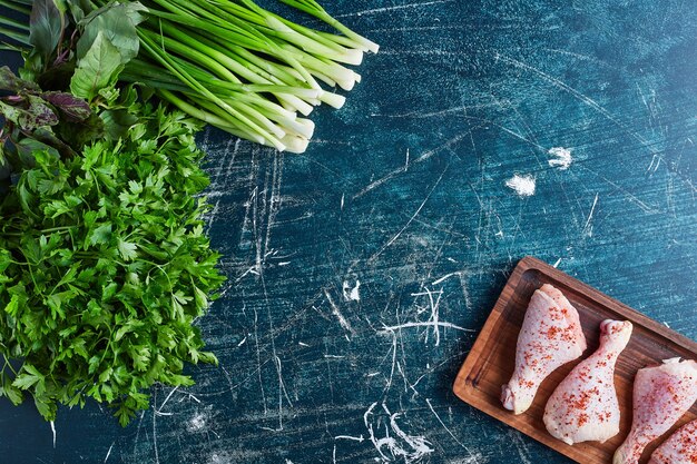 Muslos de pollo crudo sobre una tabla de madera.