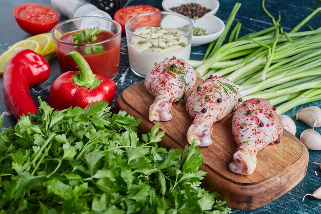 Muslos de pollo crudo sobre una tabla de madera.