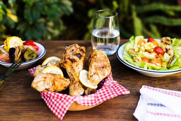 Muslos de pollo y ensalada al aire libre.