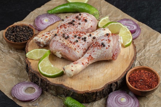 Muslos de pollo fresco crudo. con especias y verduras.