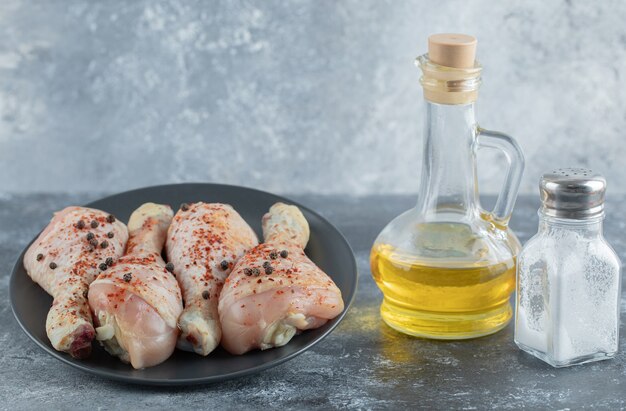 Muslos de pollo frescos marinados con aceite y sal listos para cocinar.