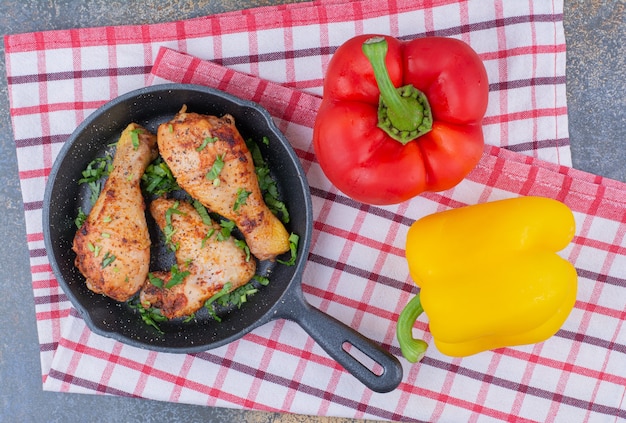 Foto gratuita muslos de pollo a la plancha en sartén con pimientos.