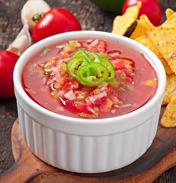 Nacho chips y salsa mexicana en un tazón de madera