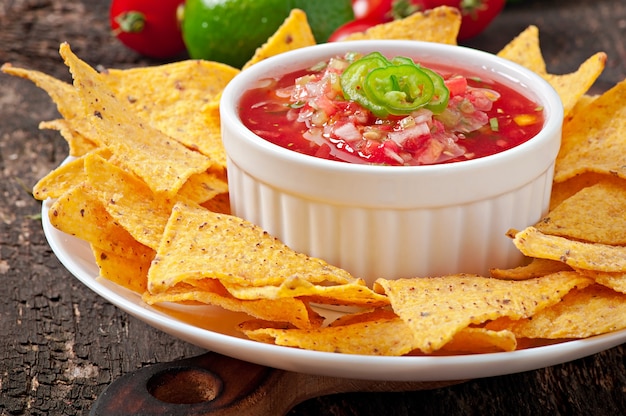 Nacho chips y salsa mexicana en un tazón de madera