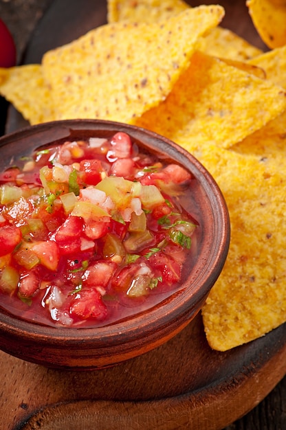 Nacho chips y salsa mexicana en un tazón de madera