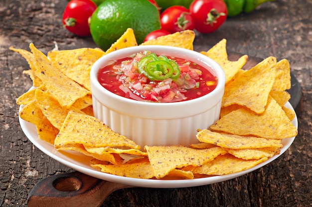 Nacho chips y salsa mexicana en un tazón de madera