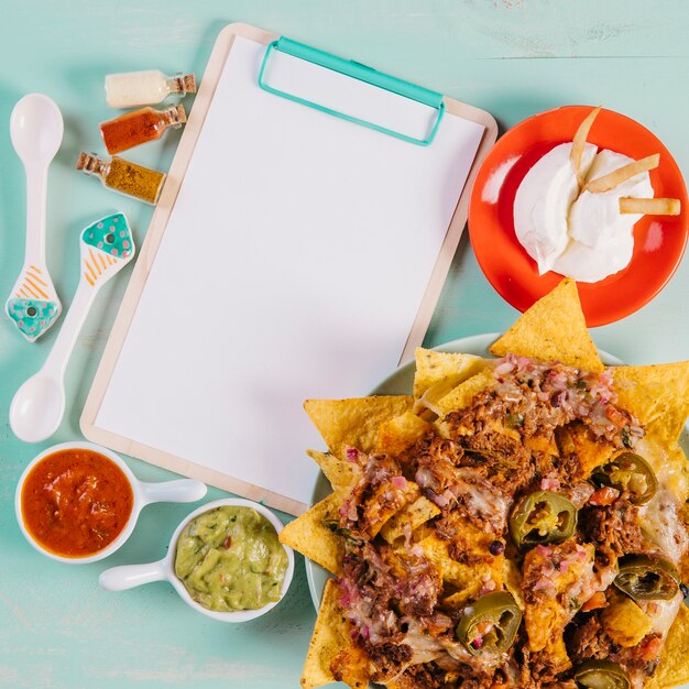 Nachos y salsas cerca del portapapeles