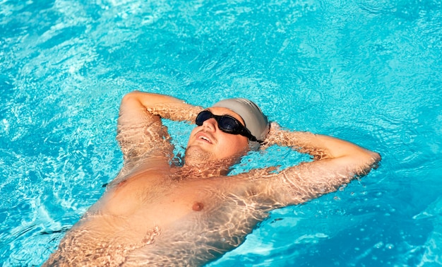 Nadador masculino flotando en la piscina