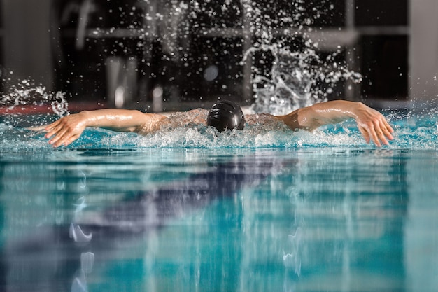 Nadador masculino nadando el trazo de mariposa