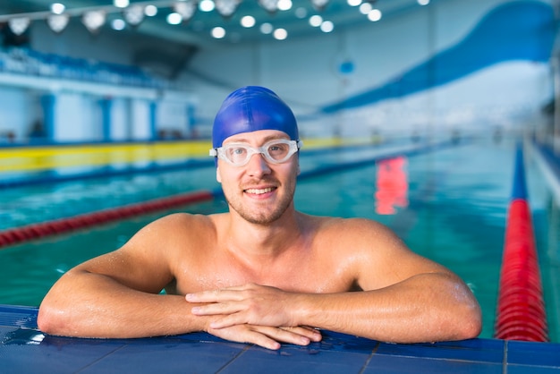 Nadador masculino de pie en el borde de la piscina