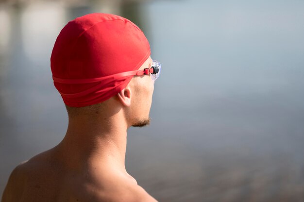 Nadador de primer plano mirando hacia el agua