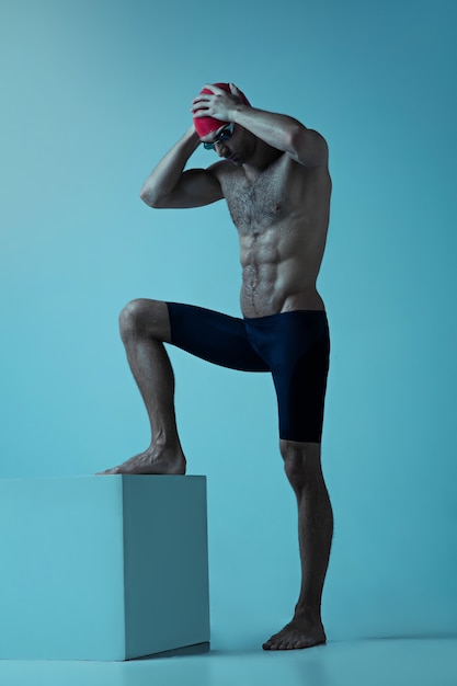 Nadador profesional masculino con sombrero y gafas en movimiento y acción, estilo de vida saludable y movimiento