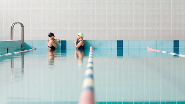 Nadadores relajantes en la piscina cubierta