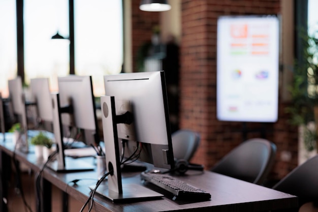 Nadie en la oficina con múltiples monitores en el mostrador de servicio al cliente, soporte de línea de ayuda del centro de llamadas para brindar asistencia de telecomunicaciones. Mesa de ayuda vacía con recepción de telefonía del cliente.