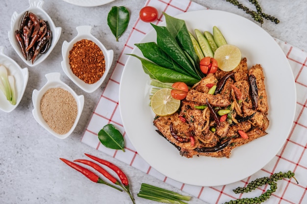 Nam Tok de cerdo con chile frito, tomate, lima, pepino y pimiento fresco. Comida tailandesa.