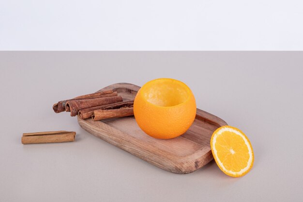 Naranja con canela sobre tabla de madera.
