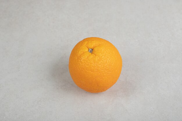 Naranja entera fresca sobre superficie gris