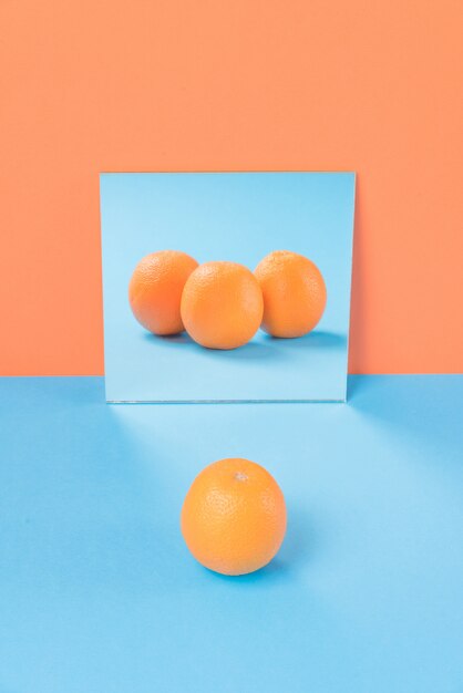 Naranja en mesa azul aislada en naranja
