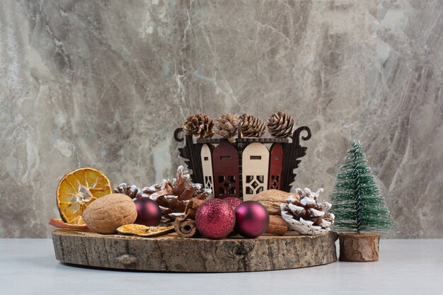 Naranja seca con piñas y bolas de Navidad en placa de madera. Foto de alta calidad