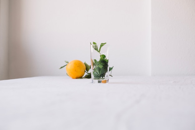 Foto gratuita naranja con vaso vacío en composición